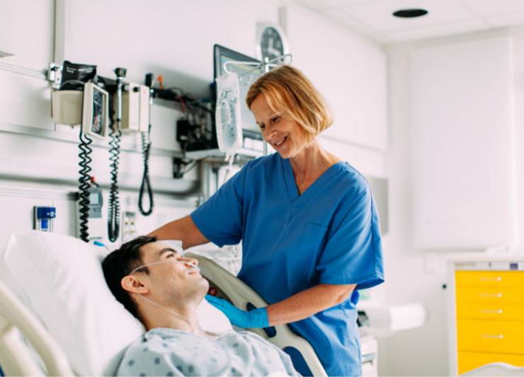 Doctor smiling at a patient laying in a hospital bed