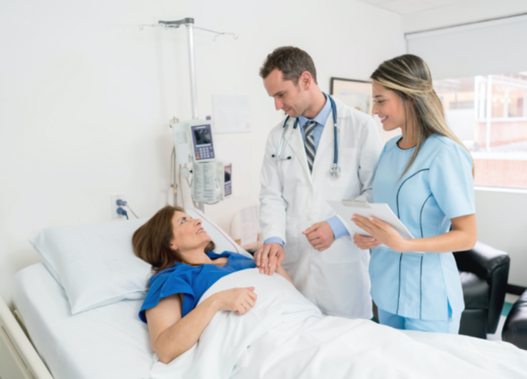 Doctor and a nurse are talking to a patient in a hospital bed