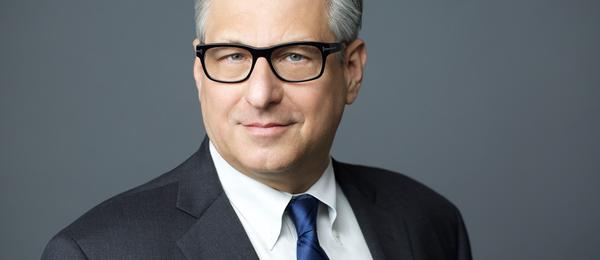 White male wearing a suite, tie and glasses